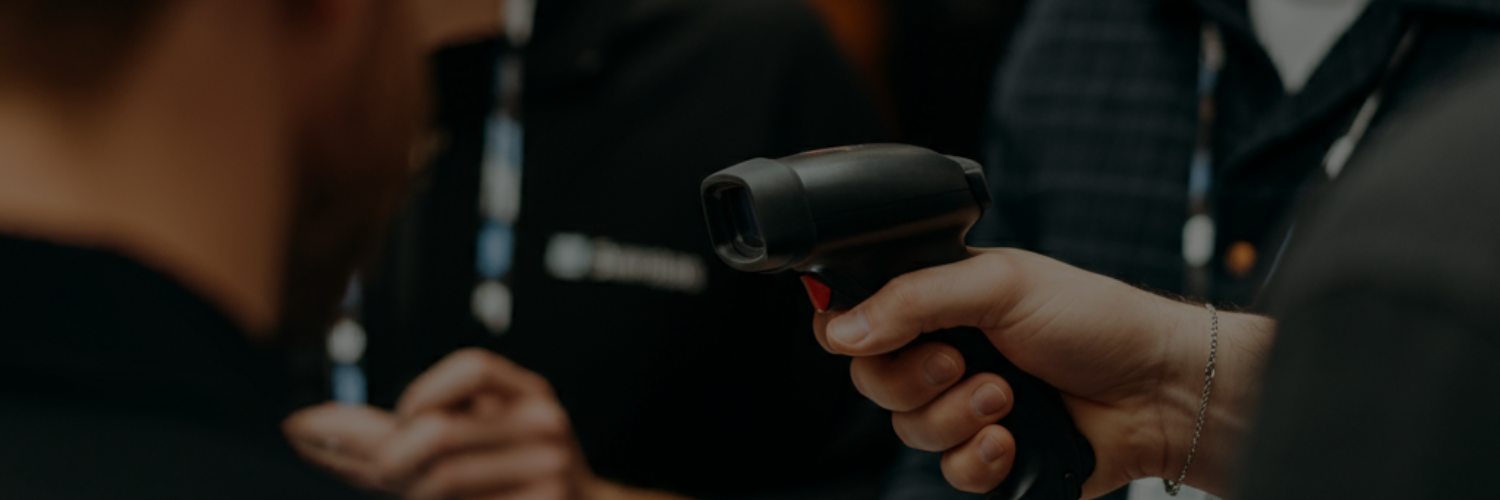 Handheld barcode scanner being used for event check‑in and badge scanning.