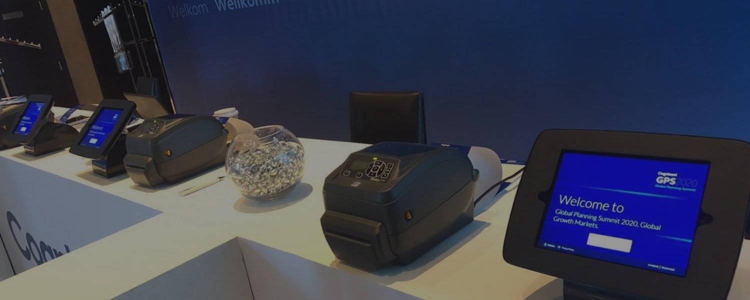 Registration desk with tablets and Zebra badge printers.